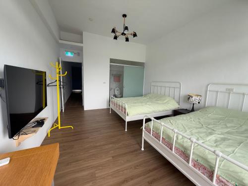 a room with two beds and a flat screen tv at Living in the mountains in San-wan