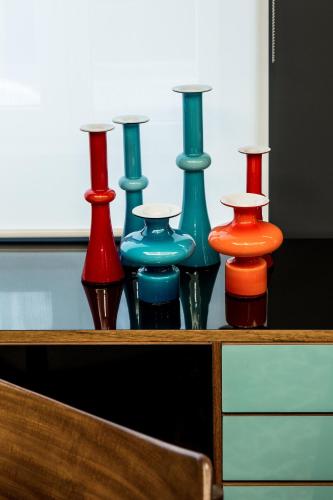 a group of different colored vases sitting on a shelf at Le Général Hôtel in Paris