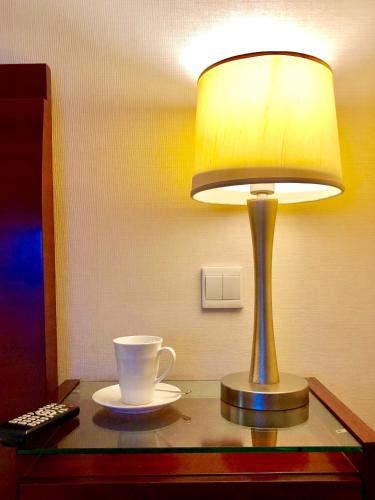 a table with a lamp and a cup on it at Ningbo Portman Plaza Hotel in Ningbo