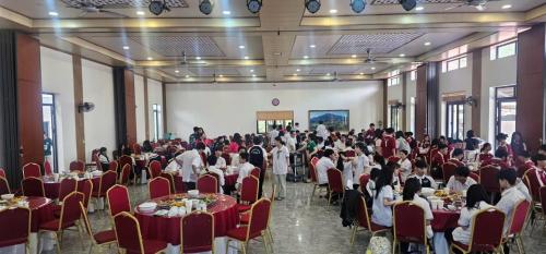a group of people sitting at tables in a banquet hall at Kolia Resort in Cao Bằng