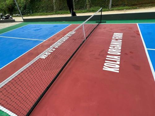 a tennis court with a net and words on it at Kolia Resort in Cao Bằng