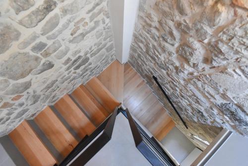 a room with a stone wall and a wooden chair at Pylon Rooms in Split