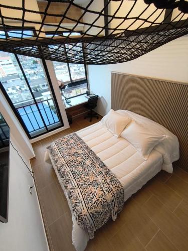 una camera da letto con un letto in una stanza con finestre di Apartamento barrio La Castellana a Bogotá