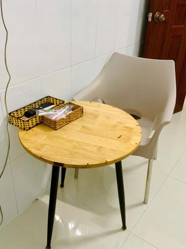a wooden table and a chair with a basket on it at Nhà nghỉ Lộc Thiên 1 in Ấp Rạch Mẹo