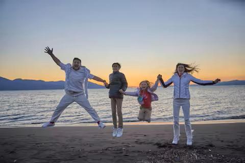 a group of three people jumping on the beach at Numazu Sparkle in Numazu