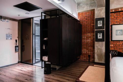 a room with a black cabinet and a brick wall at M Boutique Hotel in Ipoh
