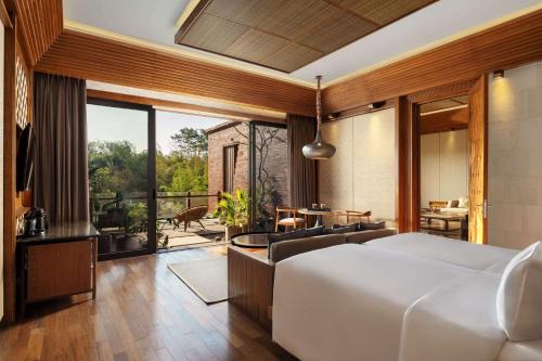 a bedroom with a large bed and a balcony at Garrya Bianti Yogyakarta in Yogyakarta