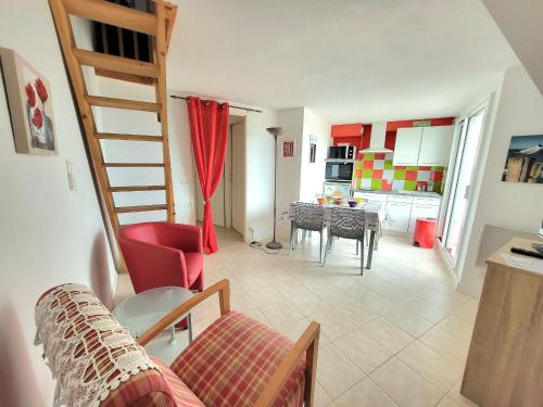un salon avec un escalier et une cuisine dans l'établissement T2 Mezzanine proche plage avec balcon - Les Sables-d'Olonne - FR-1-92-571, à Les Sables-dʼOlonne