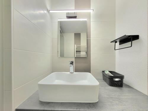 une salle de bain avec un lavabo blanc et un miroir dans l'établissement T2 Mezzanine proche plage avec balcon - Les Sables-d'Olonne - FR-1-92-571, à Les Sables-dʼOlonne