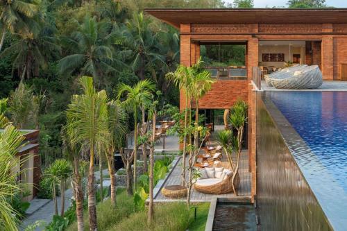 a resort with a swimming pool and palm trees at Garrya Bianti Yogyakarta in Yogyakarta