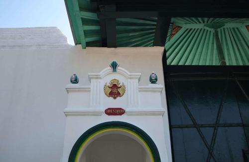 a white building with a crest on the side of it at Garrya Bianti Yogyakarta in Yogyakarta
