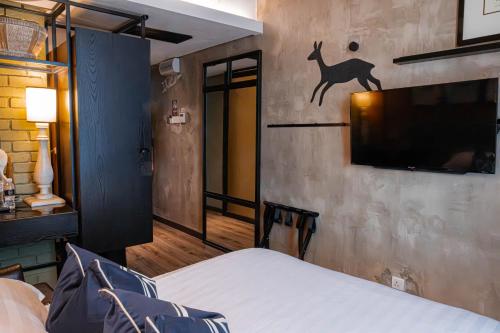 a bedroom with a bed and a tv on the wall at M Boutique Hotel in Ipoh