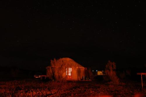 a barn in the middle of a field at night at Kyzylkum Nights Camp & Family Yurt in Nurota