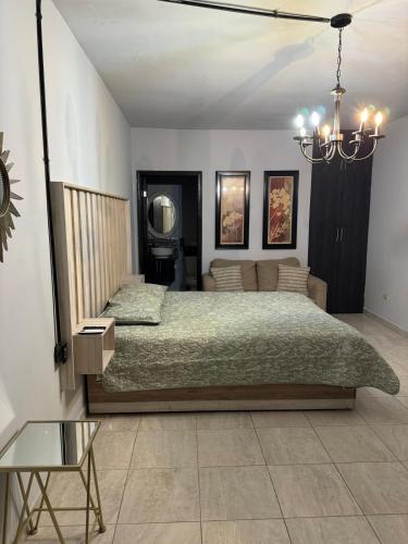 a bedroom with a bed and a table and a chandelier at Estancias Nava #6 in San Antonio