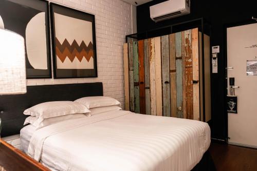 a bedroom with a white bed and some old doors at M Boutique Hotel in Ipoh