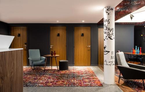 a lobby with wooden doors and chairs and a rug at Le Général Hôtel in Paris