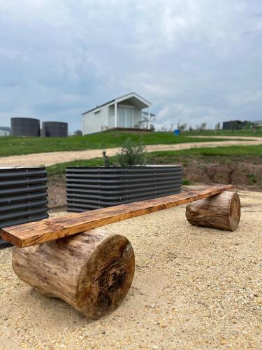 a bench made out of logs sitting on the ground at Banjos Cabin Gippsland - Luxury Eco Stay - King Bed, Pond Valley Views, Fireplace in Seaton