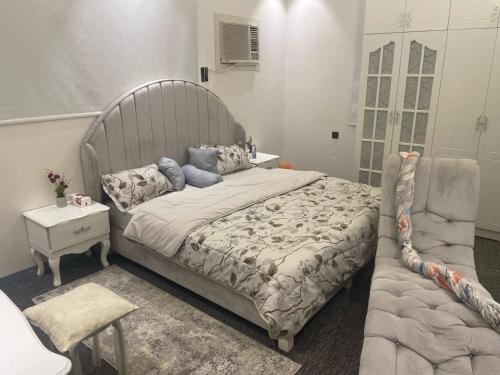 a bedroom with a large bed and a chair at منازل سارا 2 Sara Houses in Tabuk
