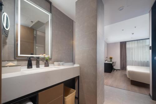 ein Badezimmer mit Waschbecken und Spiegel in der Unterkunft Atour Hotel Dalian Xinghai Square Zhongshan Road in Dalian