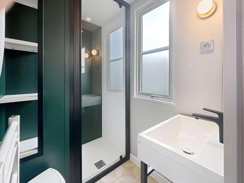 une salle de bain avec un lavabo blanc et une fenêtre dans l'établissement Mobil-home de Grand Confort à 200m de la plage avec piscine chauffée, 2 chambres, parking, wifi inclus - FR-1-361A-44, à Jullouville