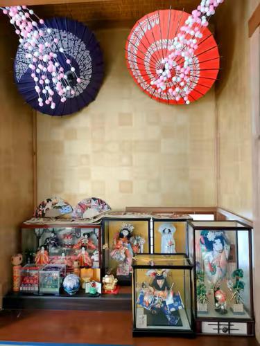 a shelf with pictures and umbrellas on a wall at Numazu Sparkle in Numazu
