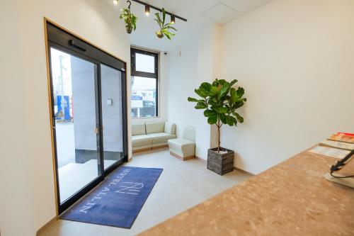 a living room with a large glass door and a potted plant at HOTEL ALL IN Kumamoto in Kumamoto