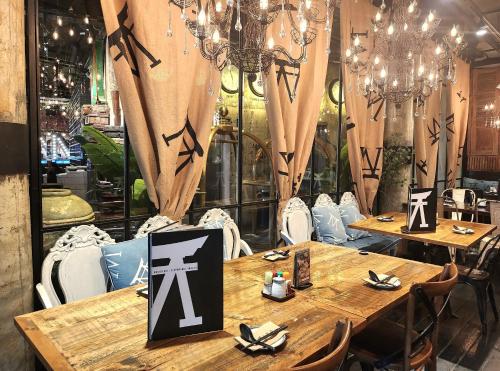 a restaurant with wooden tables and chairs with chandeliers at M Boutique Hotel in Ipoh
