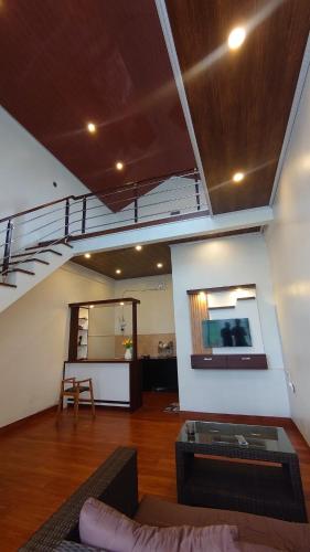 a living room with a staircase and a couch and a table at Skypiea Dieng in Dieng