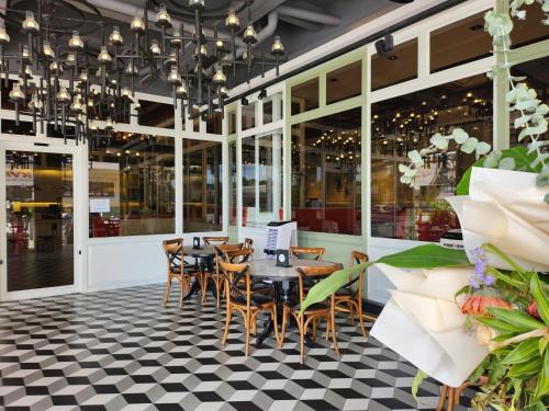a restaurant with tables and chairs on a checkered floor at M Boutique Hotel in Ipoh