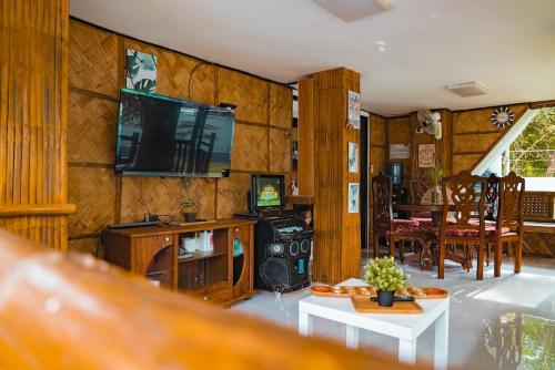 a living room with wooden walls and a tv on the wall at TANGLAW - A Private Rest house with pool near Tagaytay City in Alfonso