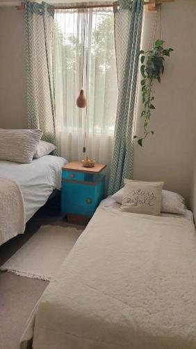 two twin beds in a room with a window at CasaNativa Sur Depto Diseño Boho in Curicó