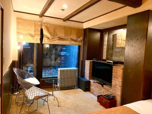 a bedroom with a bed and a tv and a fireplace at Musashino Bekkan in Hakone