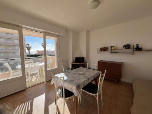 une salle à manger avec une table et des chaises et un balcon dans l'établissement Appartement familial T3 au Lavandou avec parking, 4 pers., proche plage - FR-1-308-204, au Lavandou