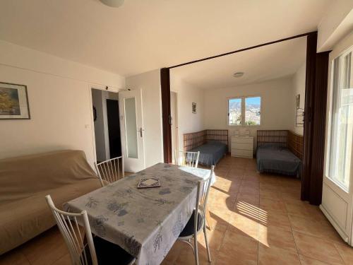 un salon avec une table et des chaises et un lit dans l'établissement Appartement familial T3 au Lavandou avec parking, 4 pers., proche plage - FR-1-308-204, au Lavandou