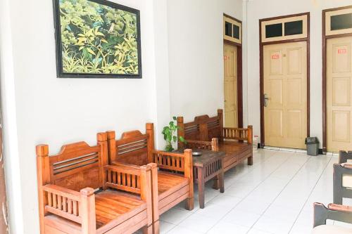 a row of wooden benches sitting in a room at D Martin Malioboro Hotel RedPartner in Sentool