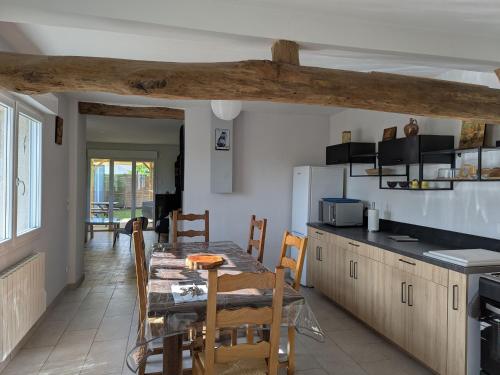 une cuisine et une salle à manger avec une table et des chaises dans l'établissement Maison familiale au bord de la Loire à Sigloy pour 6 personnes - FR-1-590-572, à Sigloy