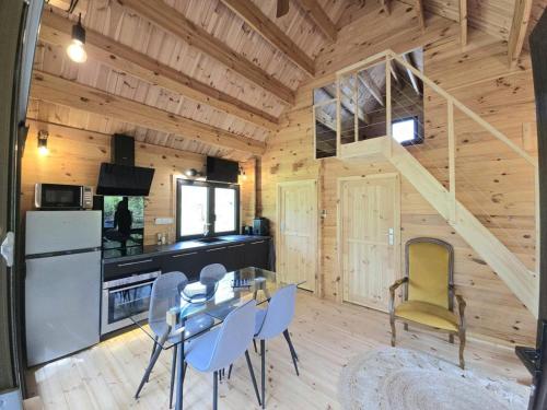 - une salle à manger et une cuisine dans une cabane en rondins dans l'établissement Chalet Médiéval à Domme avec Spa et Parking - FR-1-616-479, à Domme