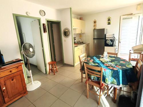 une cuisine avec une table à manger et une cuisine avec une cuisine. dans l'établissement Appartement calme 4 pers, proche plage, parking - FR-1-607-216, au Cap d'Agde