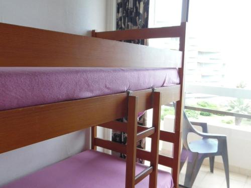 - un lit superposé avec une chaise à côté d'une fenêtre dans l'établissement Studio cabine face mer avec parking privé, Canet-Plage - FR-1-750-69, à Canet