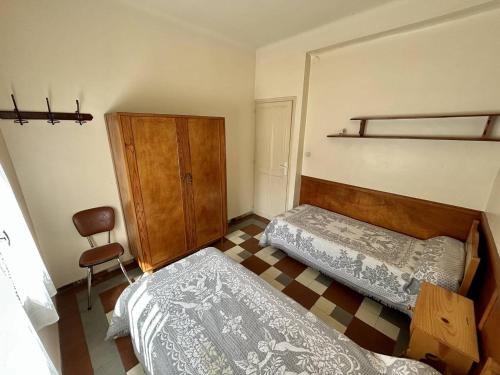 - une chambre avec deux lits et une armoire dans l'établissement Charmant T3 Rez-de-Jardin, 50m Plage, Parking Privé - FR-1-388-238, à Argelès-sur-Mer