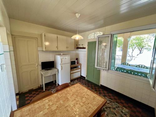 une cuisine avec un réfrigérateur blanc et une fenêtre dans l'établissement Charmant T3 Rez-de-Jardin, 50m Plage, Parking Privé - FR-1-388-238, à Argelès-sur-Mer
