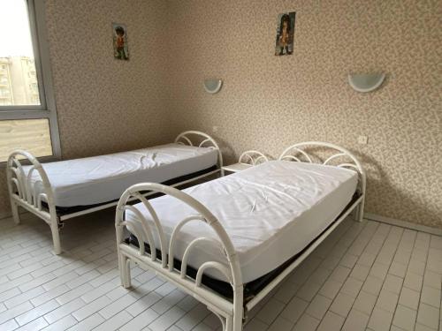 2 lits d'hôpital dans une chambre avec fenêtre dans l'établissement Appartement 3 pièces avec climatisation, parking, proche plage pour 6 personnes - FR-1-750-70, à Canet