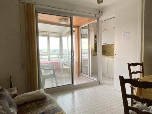 - un salon avec une porte coulissante en verre menant à une cuisine dans l'établissement Appartement 3 pièces avec climatisation, parking, proche plage pour 6 personnes - FR-1-750-70, à Canet