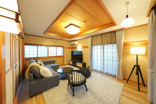 a living room with a couch and a table at パーパスリゾート EG Sky terrace 熱川 in Higashiizu