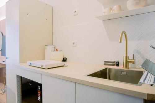 a kitchen counter with a sink and aounter at Stunning Studio Transpark Bintaro Apartment By Travelio in Tangerang