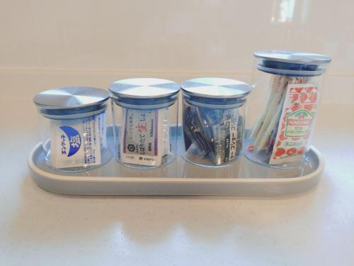 a tray with four jars of food on a counter at パーパスリゾート EG Sky terrace 熱川 in Higashiizu