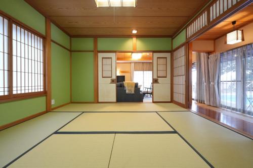 an empty room with green walls and windows at パーパスリゾート EG Sky terrace 熱川 in Higashiizu