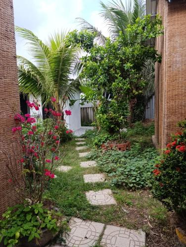a garden with palm trees and a walkway at BenTrestay in Giồng Tú Ðiền