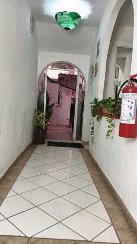 a hallway with a white tiled floor and a green light at Alexandross in Puerto Vallarta