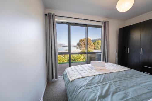 a bedroom with a laptop on a bed with a window at Lakeview Haven in Queenstown